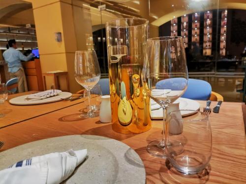 a wooden table with wine glasses on top of it at Hotel Tres Vidas Acapulco in Barra Vieja