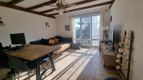 - un salon avec une table et un ventilateur de plafond dans l'établissement Cosy 2 bedrooms aprt -Argenteuil, à Argenteuil