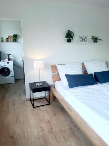 1 dormitorio con 1 cama blanca grande y mesa en Helle freundliche Wohnung am Stadtpark, en Bobingen