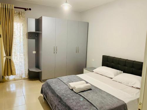 1 dormitorio con 1 cama con 2 toallas en Divjaka Apartments 2 - City Center, en Divjakë