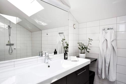 a white bathroom with a sink and a mirror at Large Architect designer home 800m from beach in Glumslöv