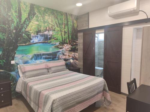 1 dormitorio con 1 cama con un mural de cascada en la pared en Hostal El Bosque Encantado Toledo, en Toledo
