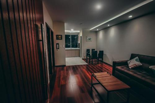 a living room with a couch and a table at Departamento con piscina y vistas hermosas in Cochabamba