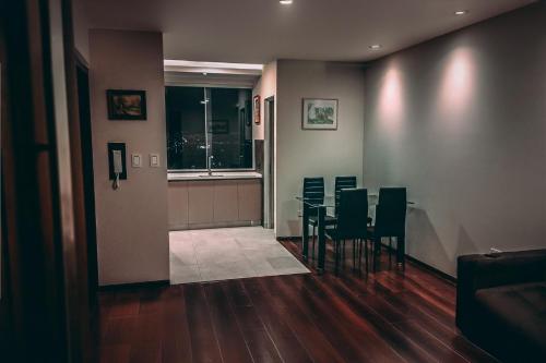 a dining room with chairs and a table and a window at Departamento con piscina y vistas hermosas in Cochabamba