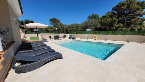una piscina con tumbonas junto a ella en Villa Victoria Paradise, en Cala en Blanes