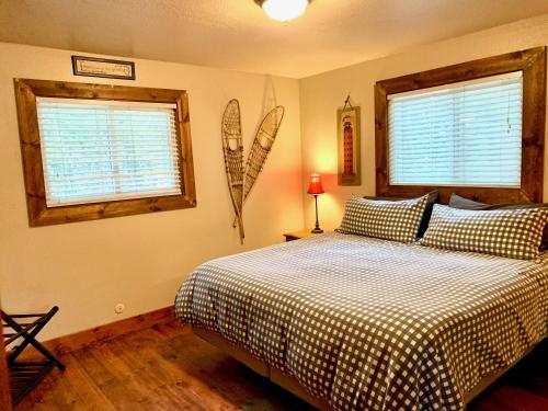 a bedroom with a bed and two windows at The Park Chalet by Casago McCall - Donerightmanagement in McCall