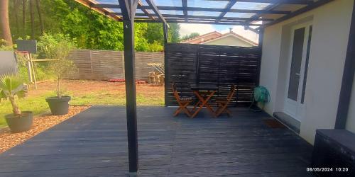 un patio con mesa y sillas en una terraza en EntreLac&Océan chambre d'hôtes chez l'habitant 2, cyclotouriste bienvenue, en Aureilhan