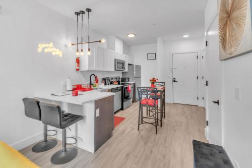 a kitchen with a counter and some chairs in it at Royal Oasis Indoor Pool, FREE Parking, Near NYC in Elizabeth