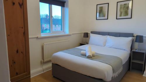 ein Schlafzimmer mit einem Bett mit einem weißen Teddybär darauf in der Unterkunft Alexander Apartments Heaton in Heaton