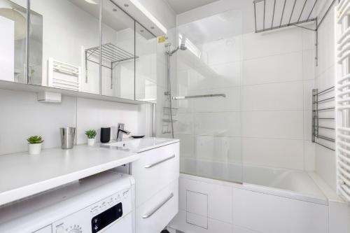 une salle de bain blanche avec un lavabo et une douche dans l'établissement Luminous & Modern Flat with Balcony Paris-Bastille, à Paris