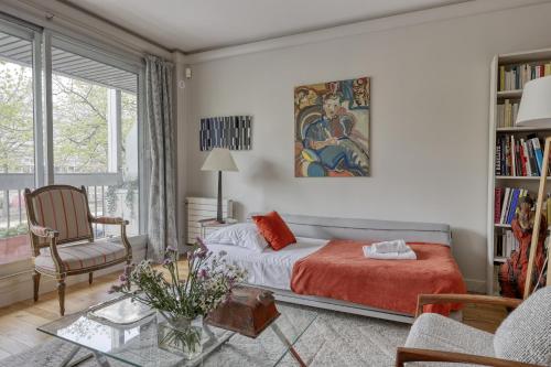 une chambre avec un lit, une chaise et une table dans l'établissement Luminous & Modern Flat with Balcony Paris-Bastille, à Paris