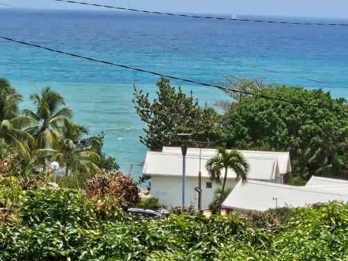 a house with the ocean in the background at Ti Oasis SEAVIEW, Studio Vue Mer à 150m de la plage in Corps de Garde