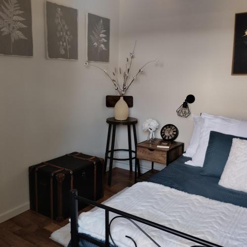 - une chambre avec un lit et une table avec des bagages dans l'établissement Maison de village en Périgord, à Singleyrac