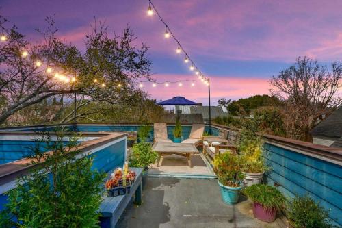 eine Dachterrasse mit einer Bank und Lichtern in der Unterkunft Elegant Sunlit Home with Private Rooftop Oasis in Charleston