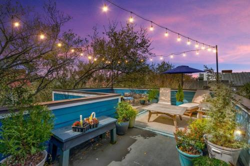 eine Terrasse mit einer Bank und einigen Pflanzen und Lichtern in der Unterkunft Elegant Sunlit Home with Private Rooftop Oasis in Charleston