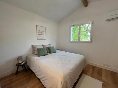 - une chambre avec un grand lit et 2 oreillers verts dans l'établissement Villa Petit Caprice - Piscine privée au calme dans jardin arboré, à Lanton
