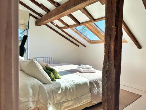 a bedroom with a bed in a room with wooden beams at El Delirio de Luna - 32800 in Pedreña