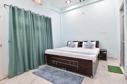 1 dormitorio con 1 cama grande y cortinas verdes en HOTEL RAMAYAN INN FREE PICKUP FROM AYODHYA DHAM RAILWAY STATION en Ayodhya