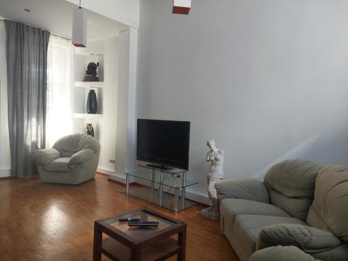 uma sala de estar com um sofá e uma televisão de ecrã plano em Apart Lwowska em Varsóvia