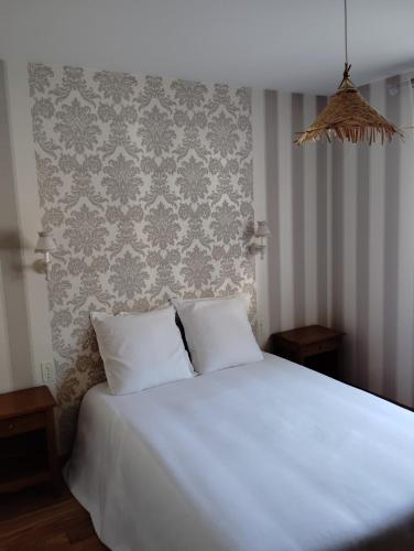 a white bed with two pillows in a bedroom at Superbe maison de famille proche du circuit des 24h in Écommoy