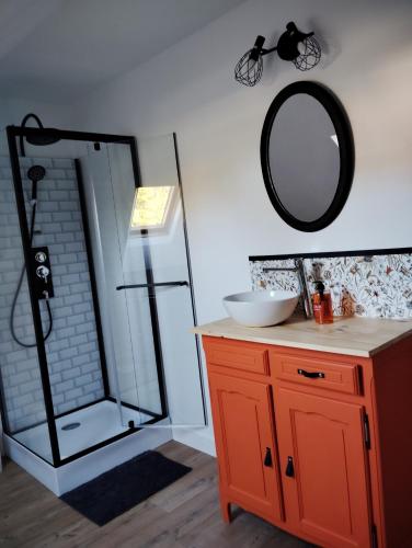 une salle de bain avec un lavabo et un miroir au mur dans l'établissement Maison de famille, à Écommoy