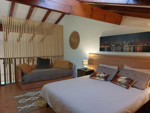 ein Schlafzimmer mit einem großen Bett und einer Couch in der Unterkunft Location de vacances Bord'O in San-Nicolao