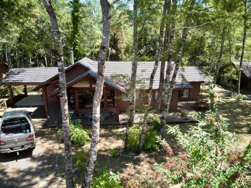 una cabaña en el bosque con un coche aparcado delante en Cabañas en Pucón, en Pucón