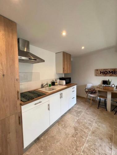 une cuisine avec des armoires blanches et une table dans l'établissement Duplex a 2 pas de la vielle ville d Avignon, à Avignon