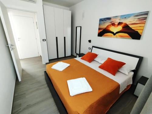 a bedroom with a large bed with orange pillows at L'Angolo di Mimma in Porto Cesareo