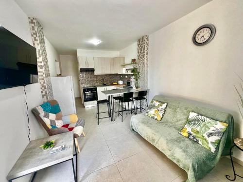 a living room with a couch and a clock on the wall at Stay With Oleg C111 in Paralimni