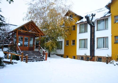 un edificio giallo con neve per terra di La Balconada by DOT Boutique a Villa Pehuenia