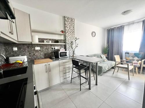 a kitchen and living room with a table and a couch at Stay With Oleg C111 in Paralimni