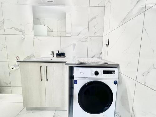a washing machine in a bathroom with a sink at Stay With Oleg C111 in Paralimni