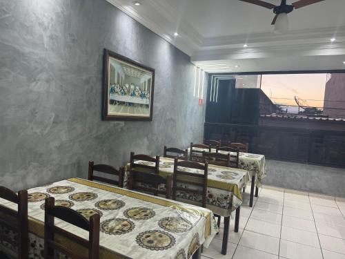 une salle à manger avec des tables, des chaises et un piano dans l'établissement Pousada Rabake, à Aparecida