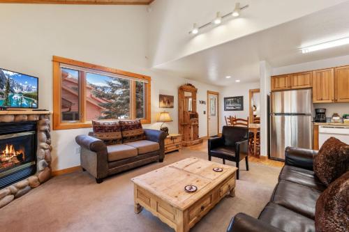 a living room with a couch and a fireplace at Bugle Pointe A08 by Estes Park Condos in Estes Park