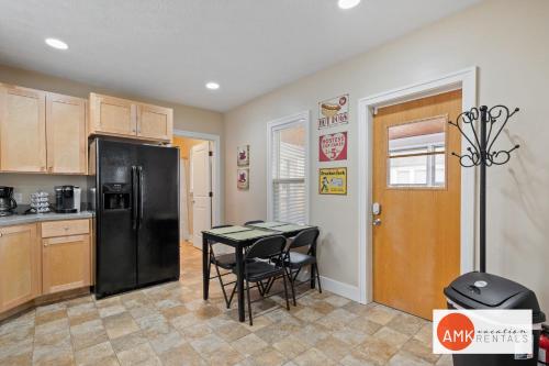 a kitchen with a black refrigerator and a table and chairs at Downtown Holland Charmer in Holland