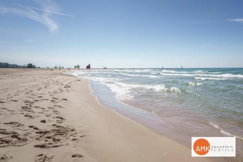 a beach with footprints in the sand and the ocean at Downtown Holland Charmer in Holland