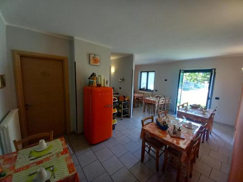 een woonkamer met tafels en een rode koelkast bij Suite Onorio B&B Zia Vivina in Sorico