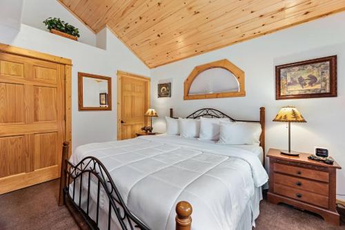 a bedroom with a large bed and a wooden ceiling at Bugle Pointe A10 by Estes Park Condos in Estes Park
