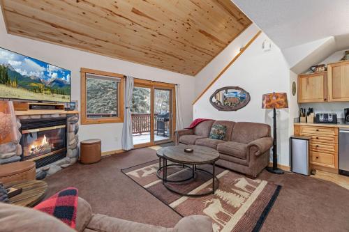 a living room with a couch and a fireplace at Bugle Pointe A10 by Estes Park Condos in Estes Park
