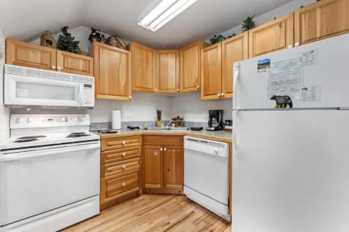 a kitchen with white appliances and wooden cabinets at Bugle Pointe A12 by Estes Park Condos in Estes Park