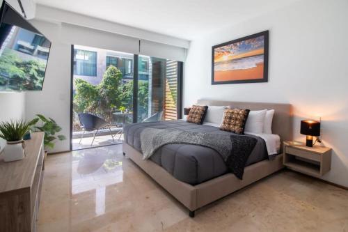a bedroom with a bed and a table and some windows at A Perfect Place in Playa del Carmen