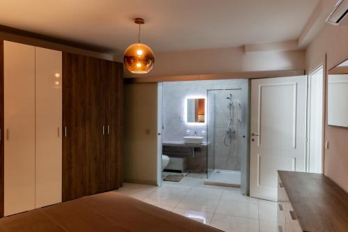 La salle de bains est pourvue d'un lavabo, de toilettes et d'une douche. dans l'établissement Deluxe 3BR Oasis with Pool next to St Julians, à Is-Swieqi