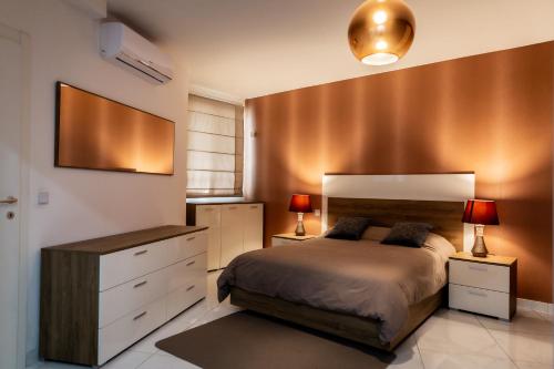 - une chambre avec un lit et une commode avec deux lampes dans l'établissement Deluxe 3BR Oasis with Pool next to St Julians, à Is-Swieqi