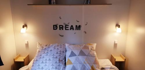 sypialnia z łóżkiem z napisem snu na ścianie w obiekcie MH camping 4 étoile Mer/forêt w mieście Soulac-sur-Mer