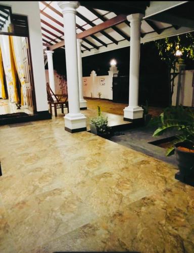 eine Terrasse mit zwei Säulen, einem Tisch und Stühlen in der Unterkunft Villa marina in Marawila