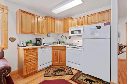 a kitchen with a white refrigerator and wooden cabinets at Bugle Pointe A15 by Estes Park Condos in Estes Park