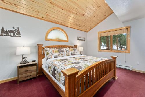 a bedroom with a wooden bed and a window at Bugle Pointe A15 by Estes Park Condos in Estes Park