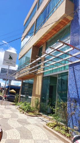 a large glass building with a sign in front of it at Brisas do Mar HOTEL & APART in Valença