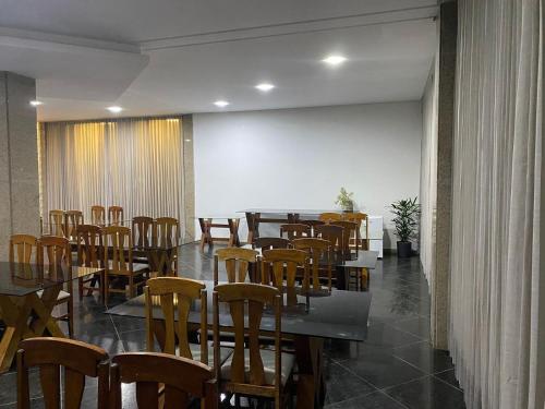 una sala da pranzo con tavoli e sedie in legno di BRISAS DO MAR HOTEL a Valença